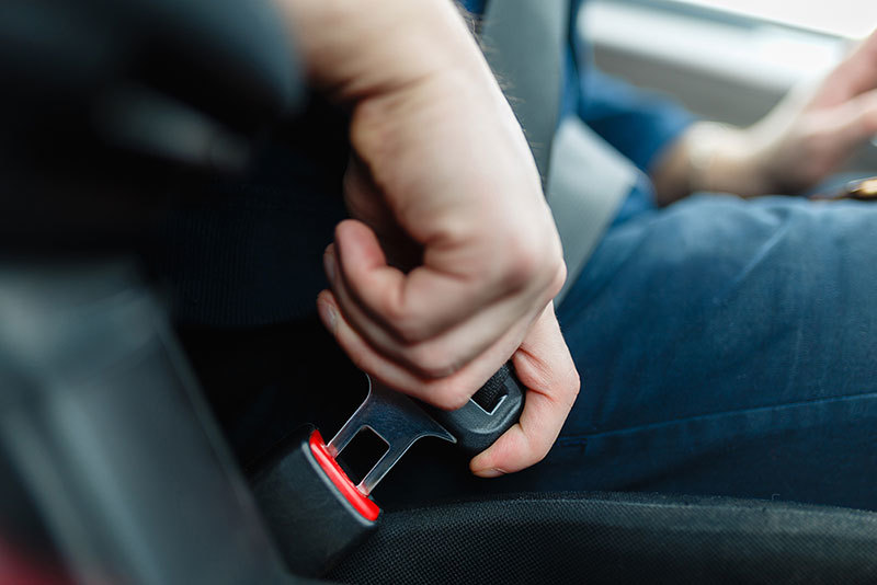 Person in a car clicking in their seatbelt